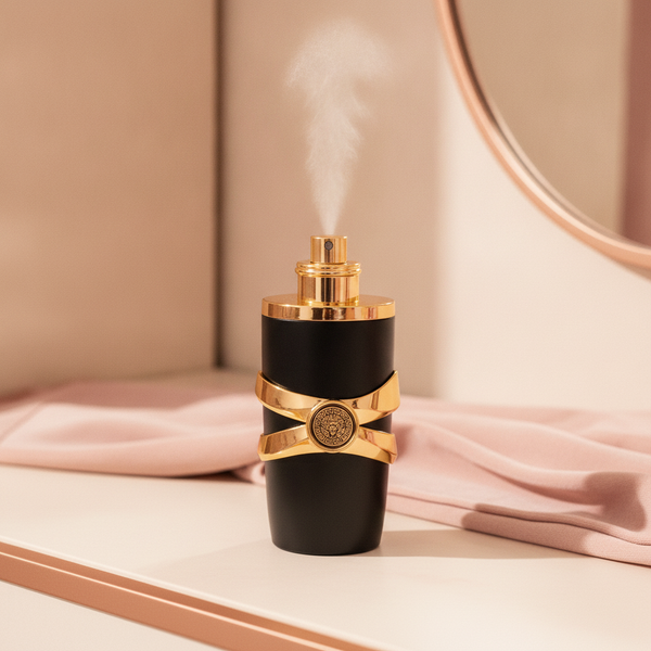 A high-angle close-up of the Desert Bloom Luxe Perfume bottle on a cream vanity with a blush pink textile, a subtle mist risi
